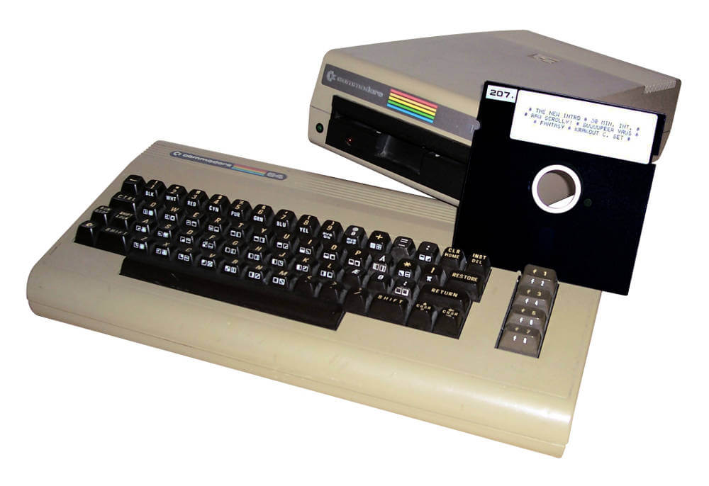 Photo of a beige Commodore 64 home computer from the 1980s with a matching floppy drive
