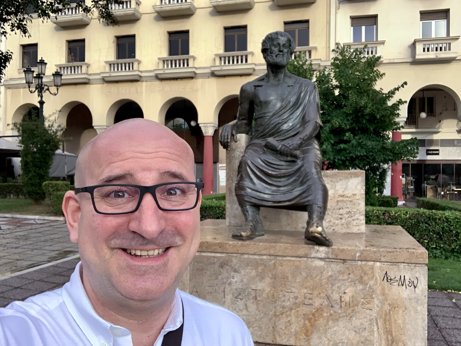 Marin standing in front of a statue of Aristotle