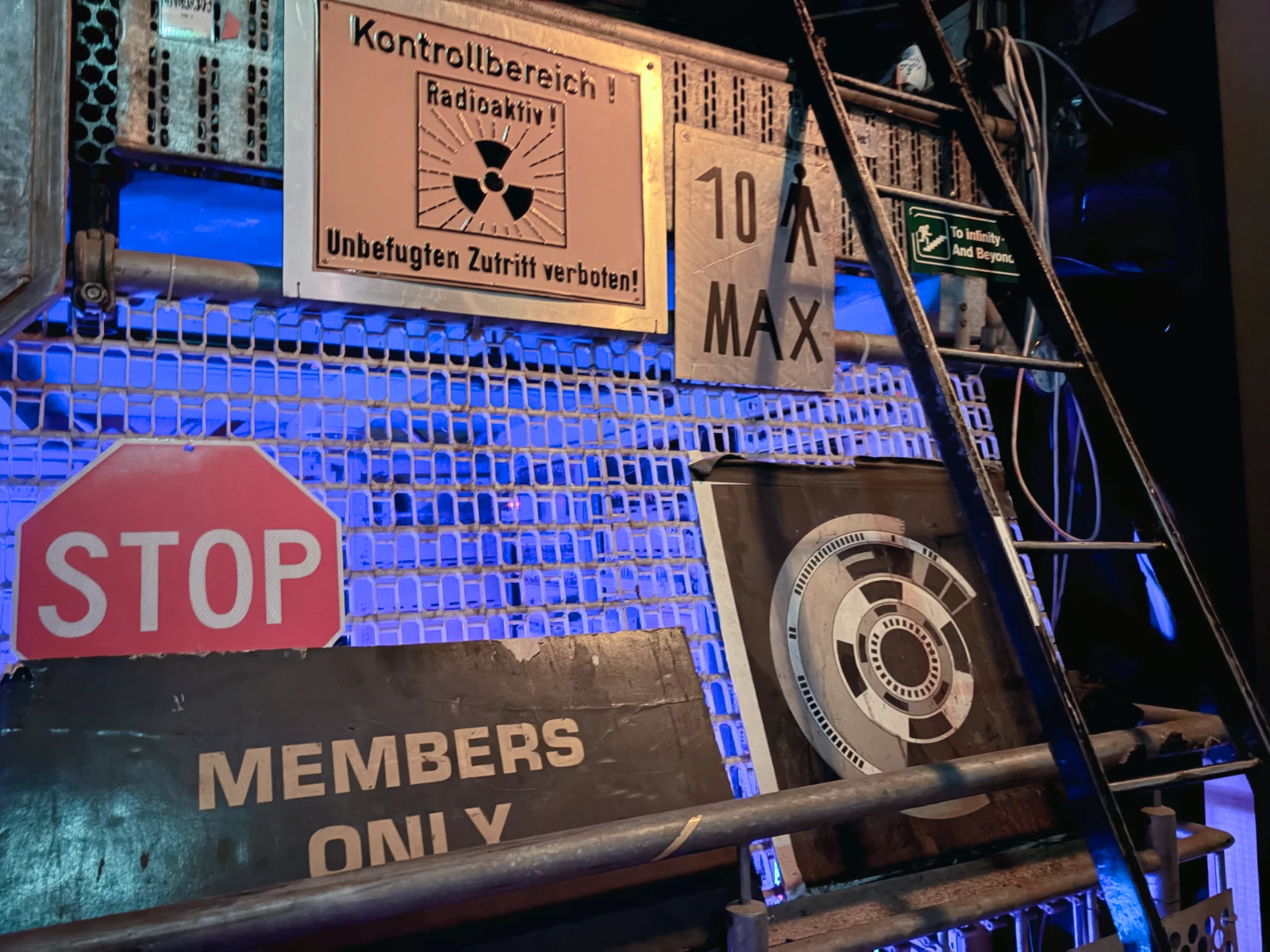A large number of signs saying 'Members Only' and warning of danger and radioactive materials, which are posted on the wall at C-Base.