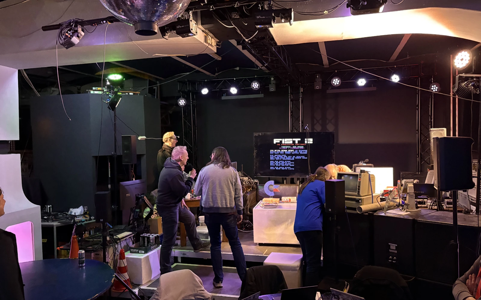 Two men standing in front of a projected screen in C-Base holding microphones and singing passionately to SID music.