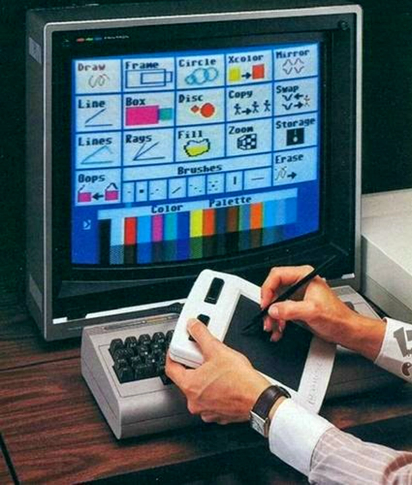 A user drawing on the Koala Pad with a stylus while it is attached to a Commodore 64