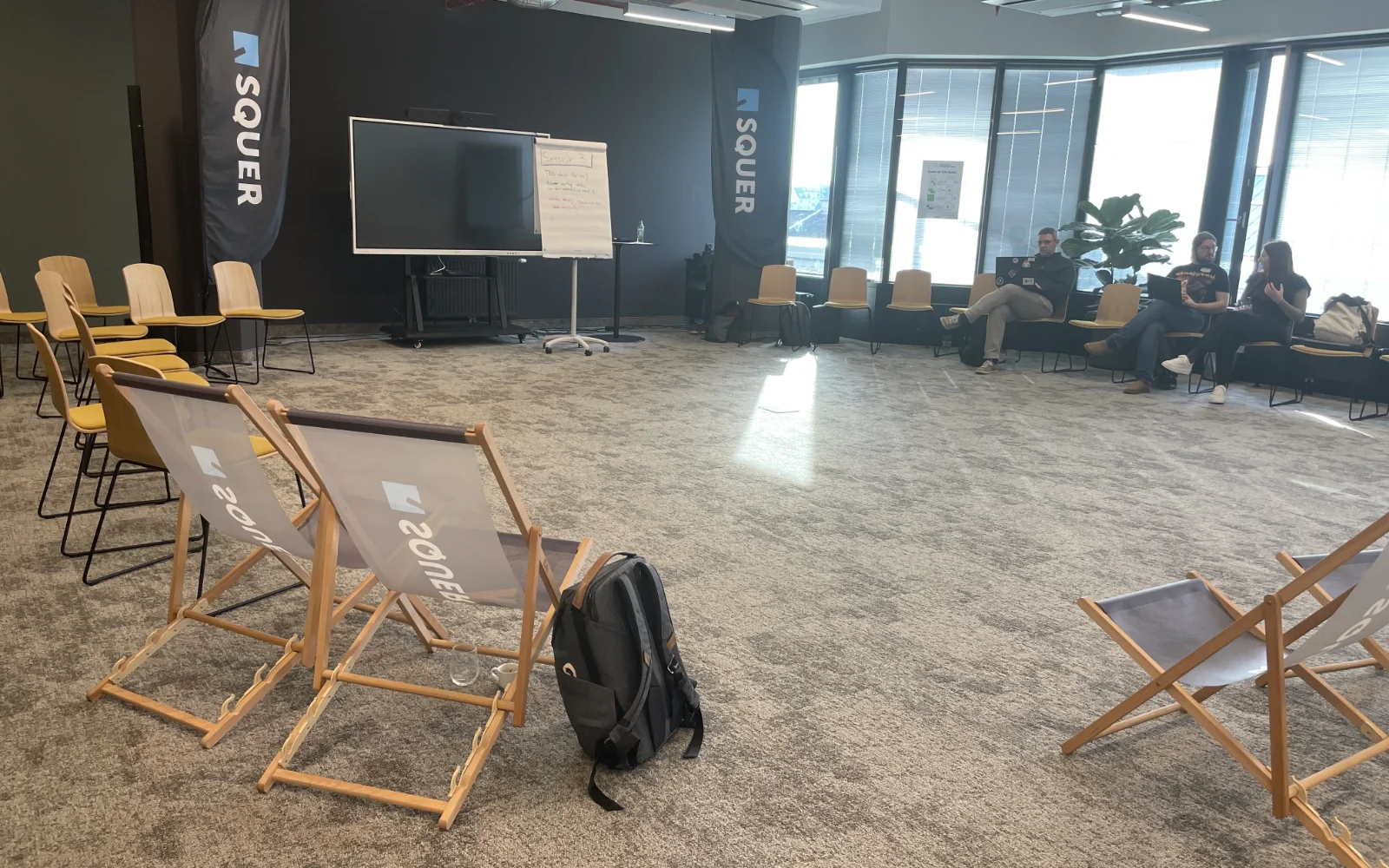 A large conference room with chairs arranged in a circle in front of a screen