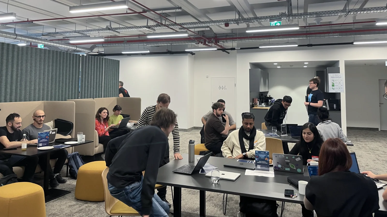 Participants sitting at tables in the office working on their code