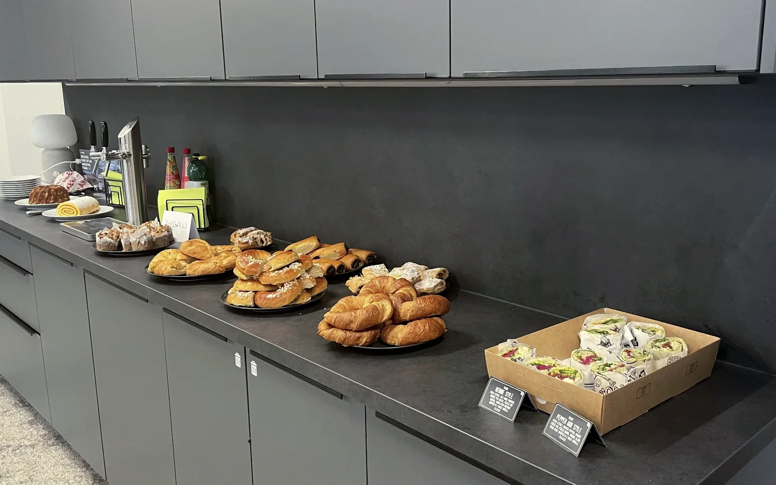 A kitchen counter top with pastries and wraps