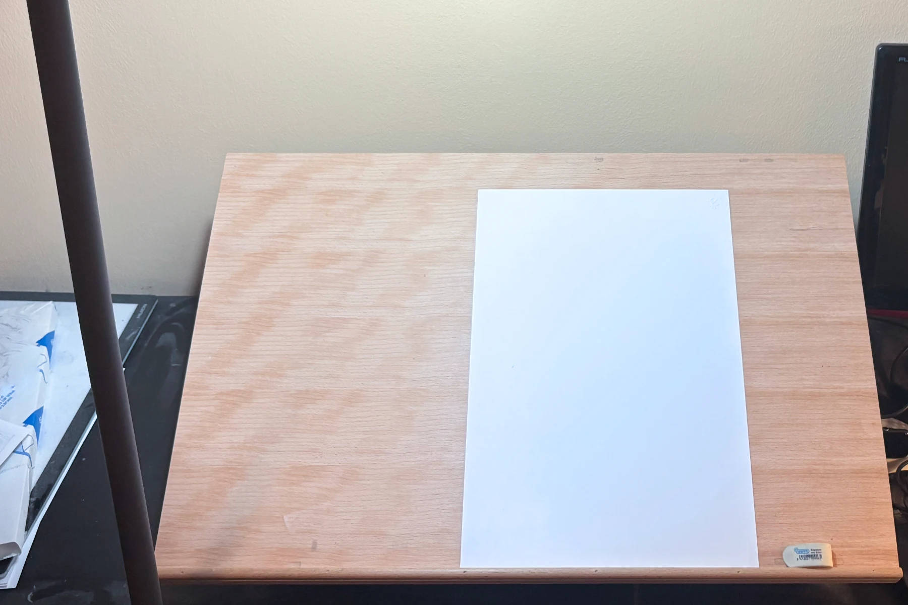 Wooden drawing board with a piece of paper on it.