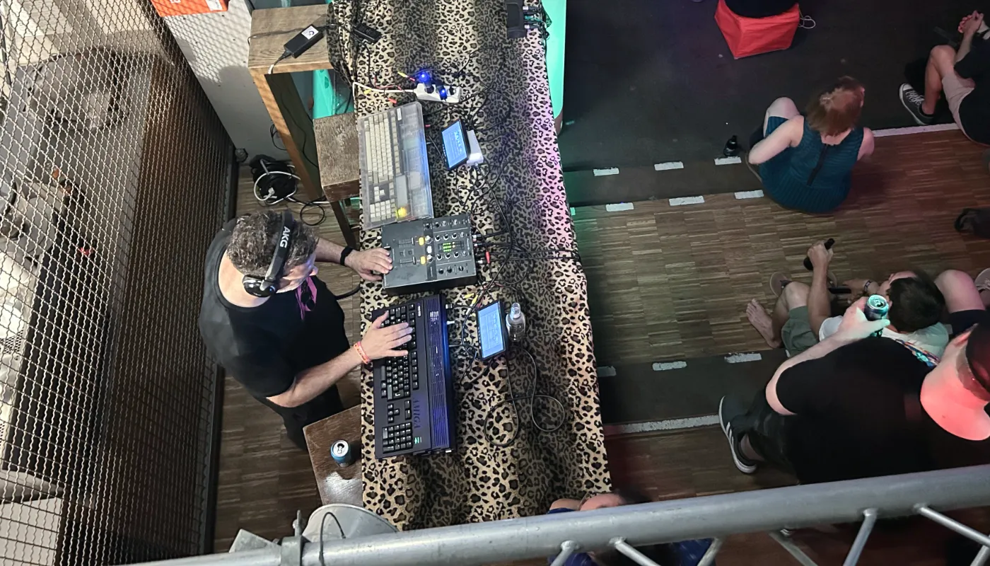A top view of a DJ at a turntable with two Amiga 1200s.