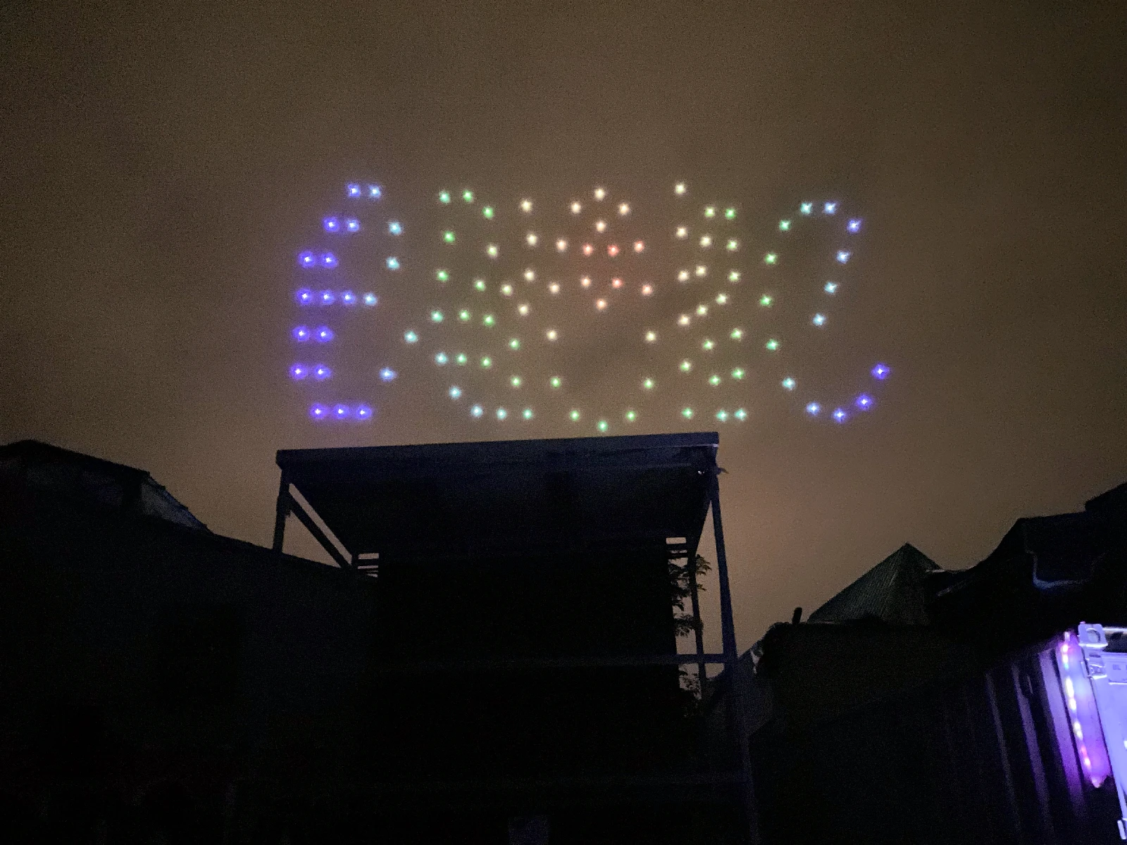 The drone light show forming shapes in the night sky over the AbenteuerhallenKALK.