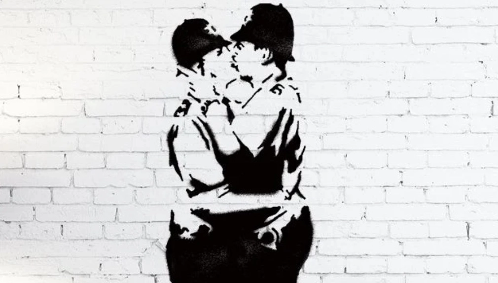 Banksy's stencil mural showing two British policemen kissing.