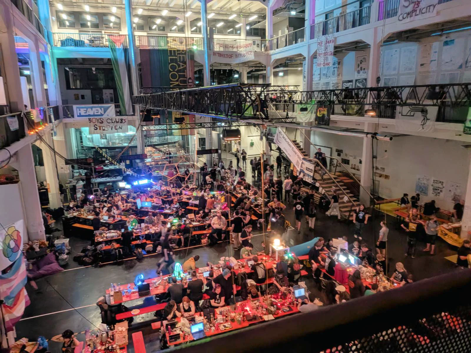 Interior view of crowded ZKM hall with colorful lighting and rows of tables