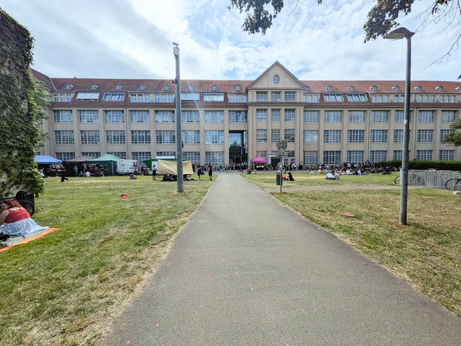 ZKM building exterior with courtyard lawn and attendees relaxing