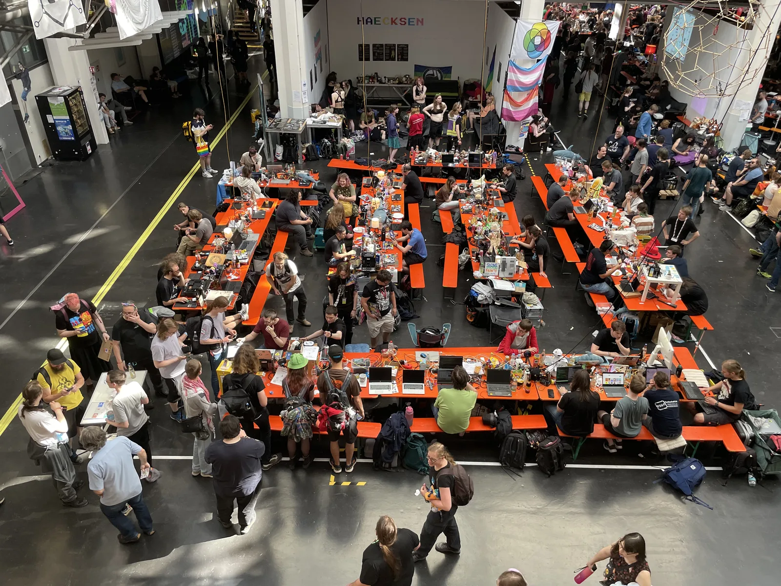 The main hall of the ZKM from above, rows of orange tables packed with hackers, banners hanging from the balconies.