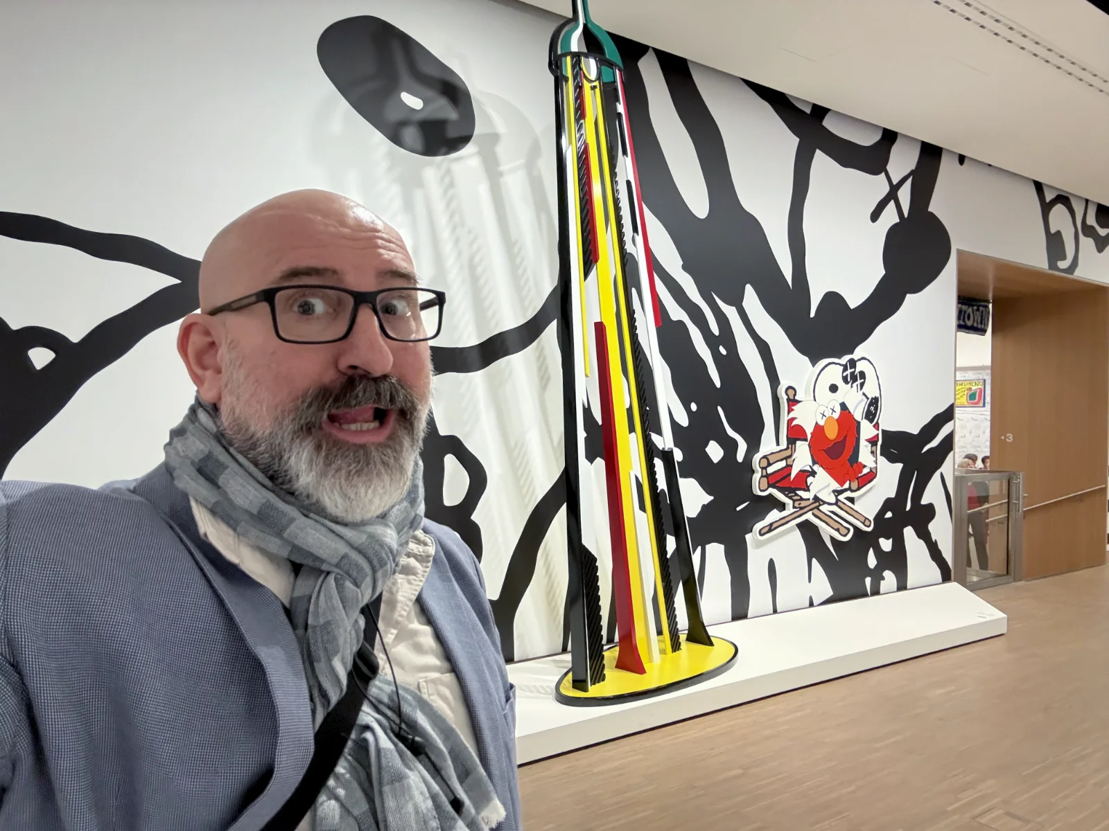 Entrance to the KAWS Art & Comix exhibition featuring bold black and white typography.