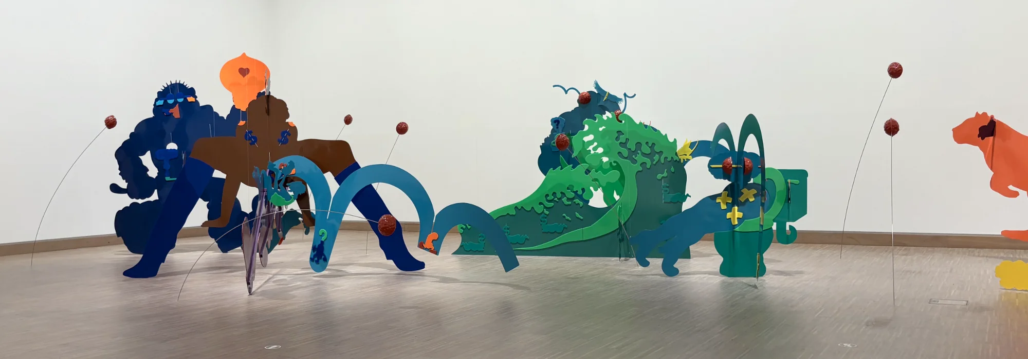 Large colorful cutouts of meatballs and comic figures suspended from the ceiling as part of the 'Meatball Curtain' installation.