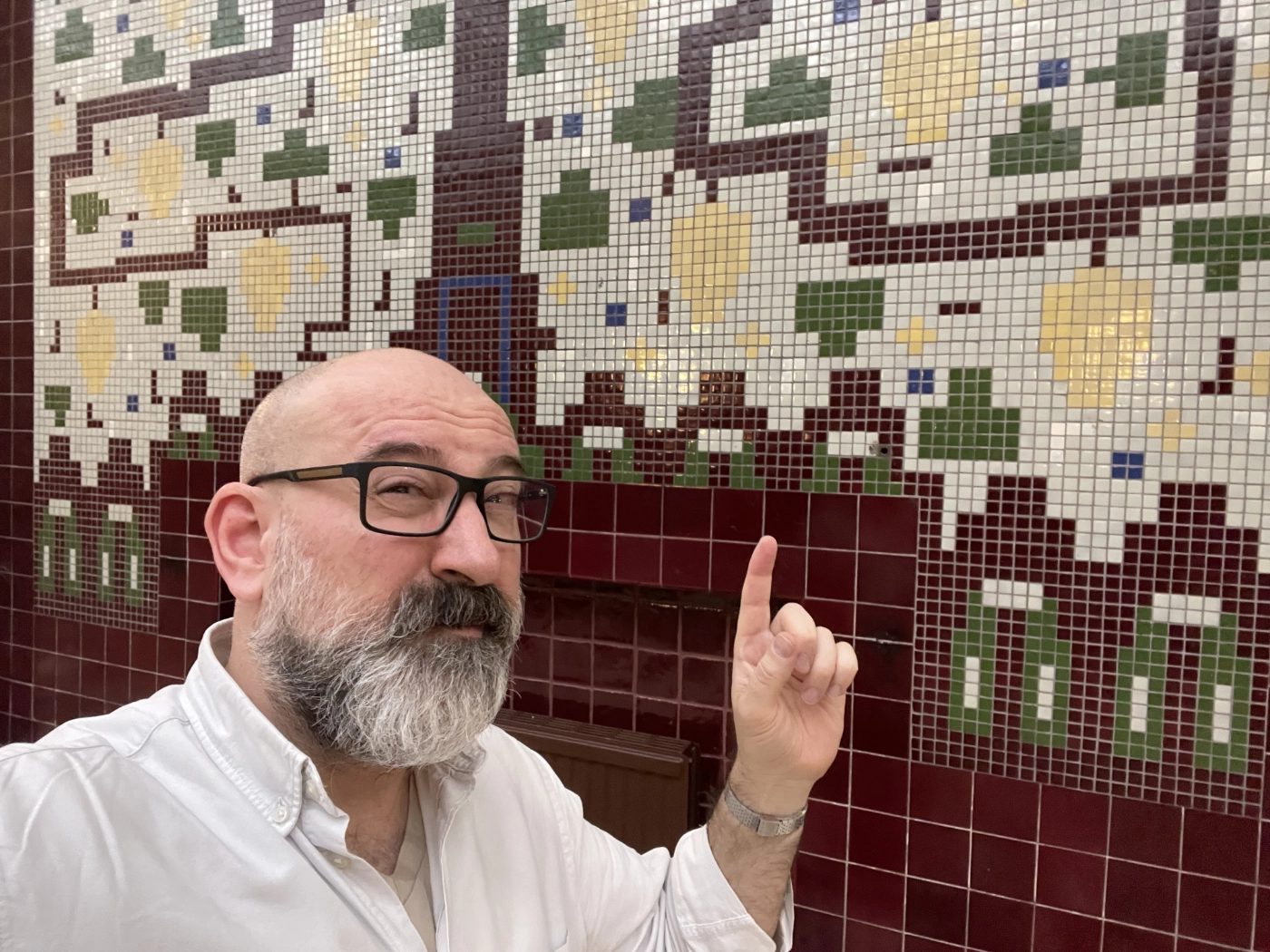 Marin standing in front of a wall mosaic