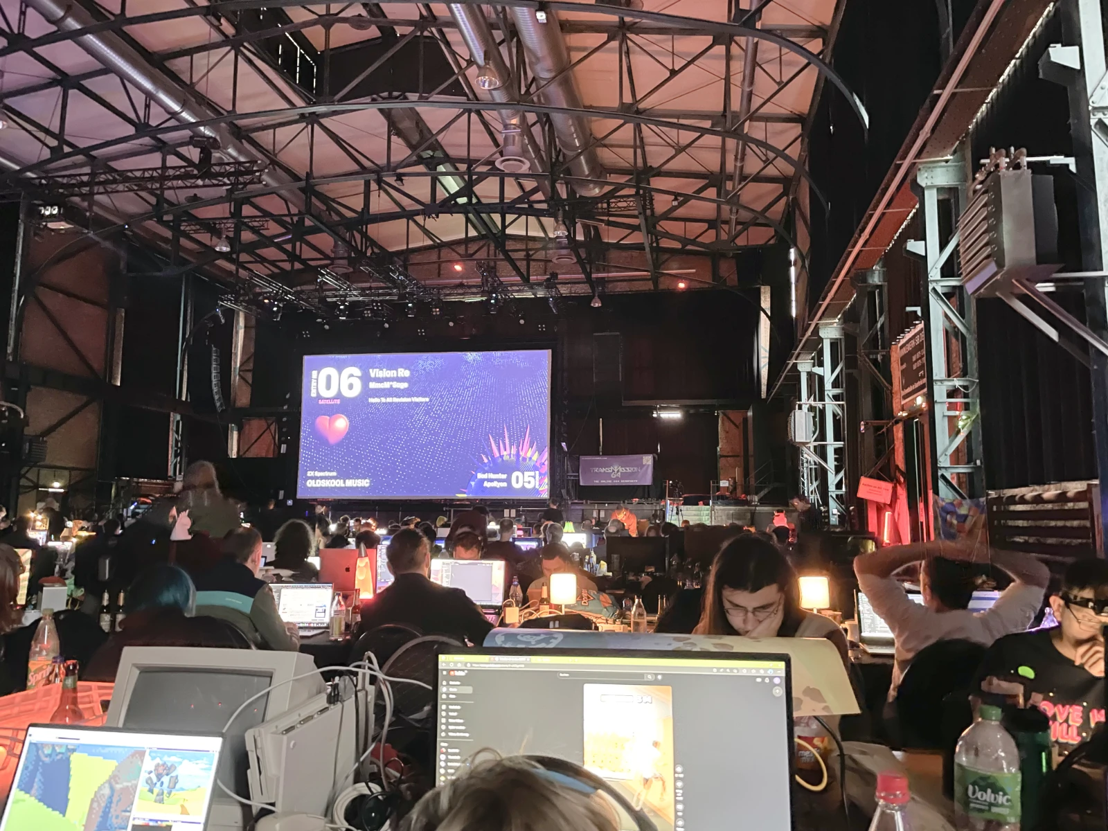 A detailed view of desks and setups inside the main hall at Revision.