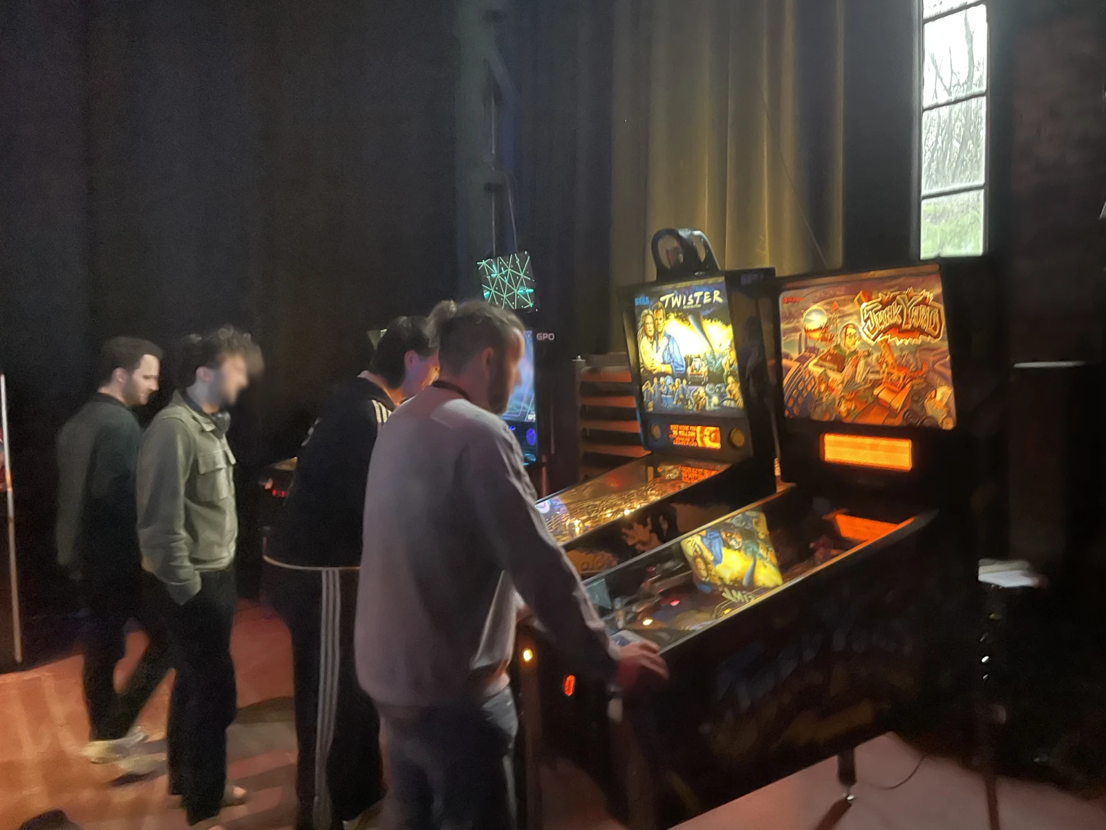 Pinball machines in the event area with bright lights.