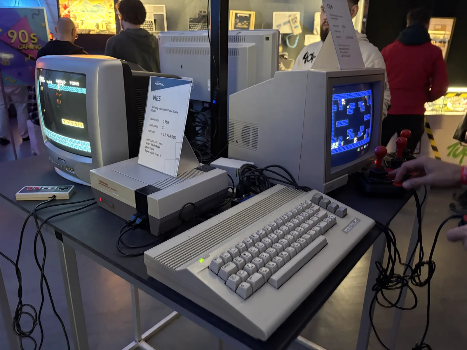 A NES and a Commodore 64C, each connected to its own CRT monitor, side by side on a table.