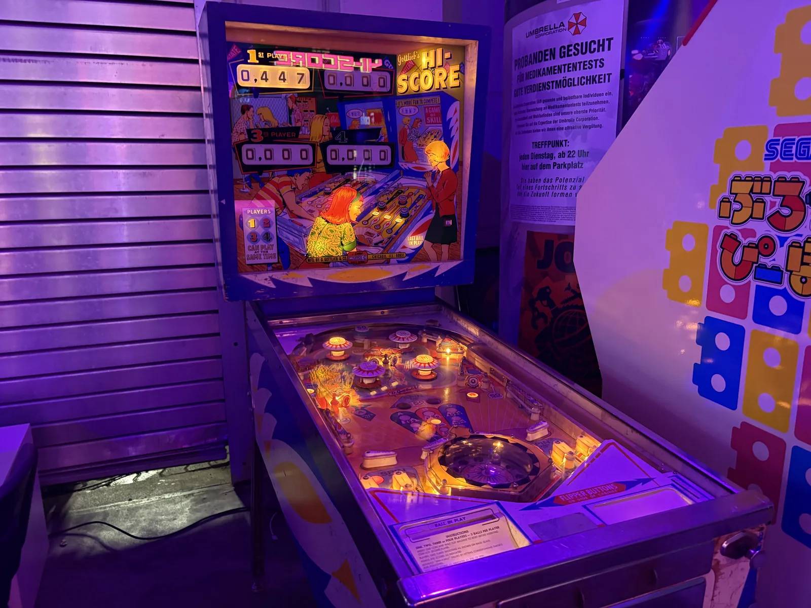 A vintage pinball machine glowing under purple light.